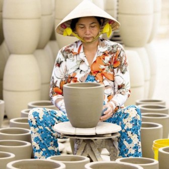 a skillful Co Chien worker is doing some vases 